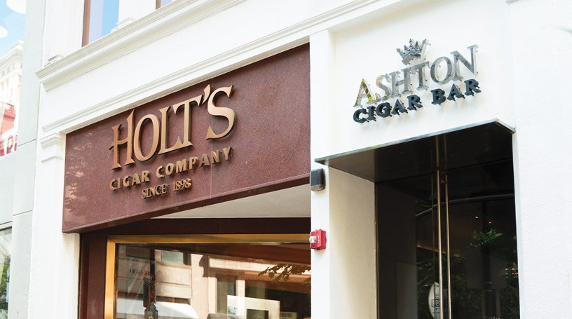 Holt's Center City: a Walnut Street storefront with a 'Holt's Cigar Company, Since 1898' sign, sharing a facade with the Ashton Cigar Bar entrance.